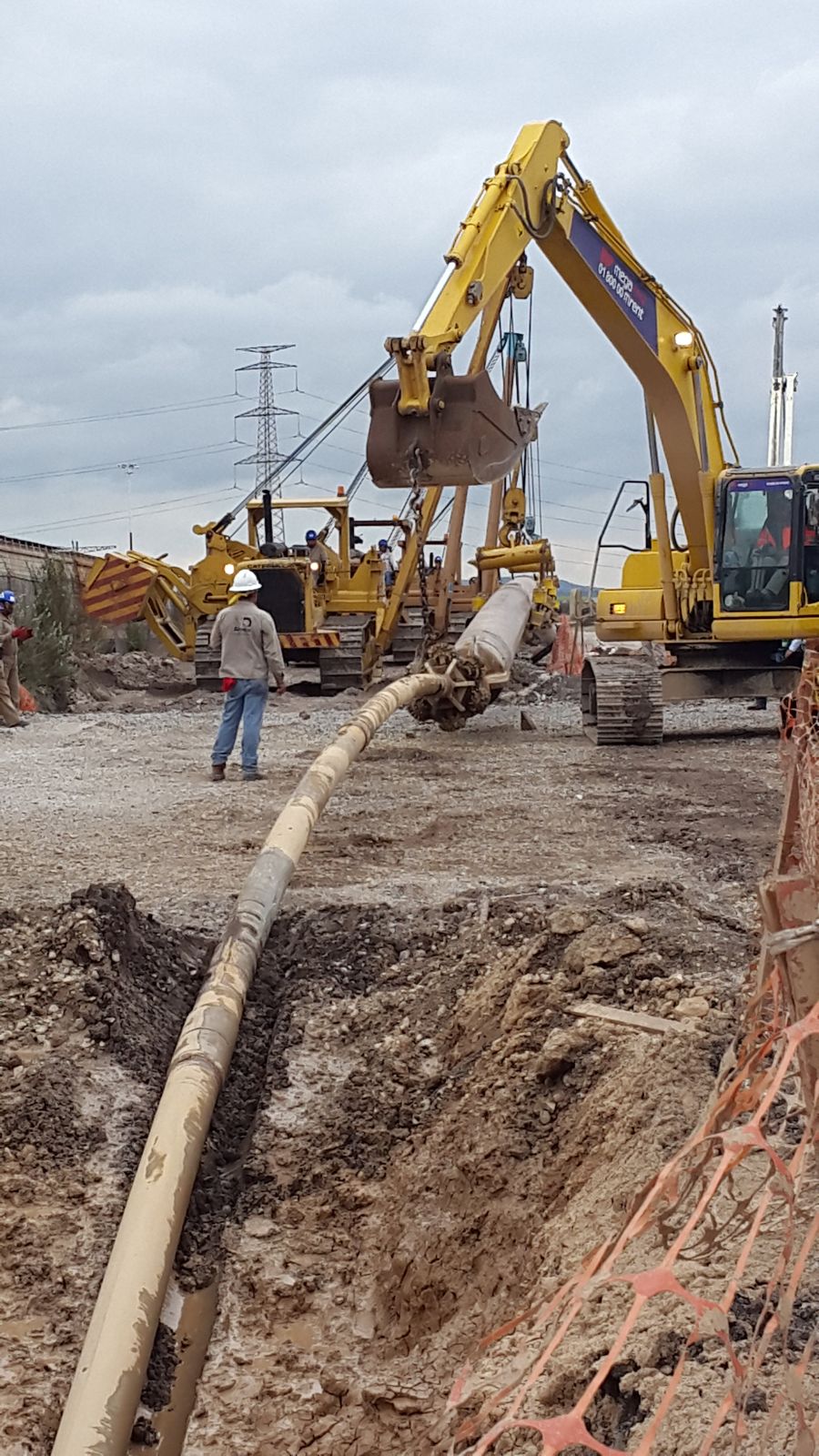 Tiende tubos bajando tubería a la zanja