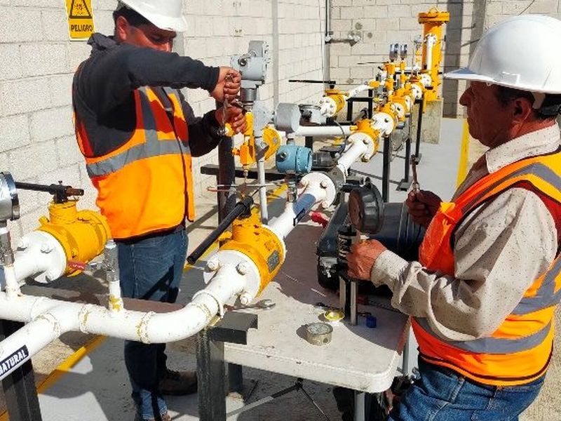 Técnicos revisando reguladores en una estación de gas